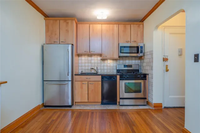 a kitchen with granite countertop wooden floors a stove and a refrigerator