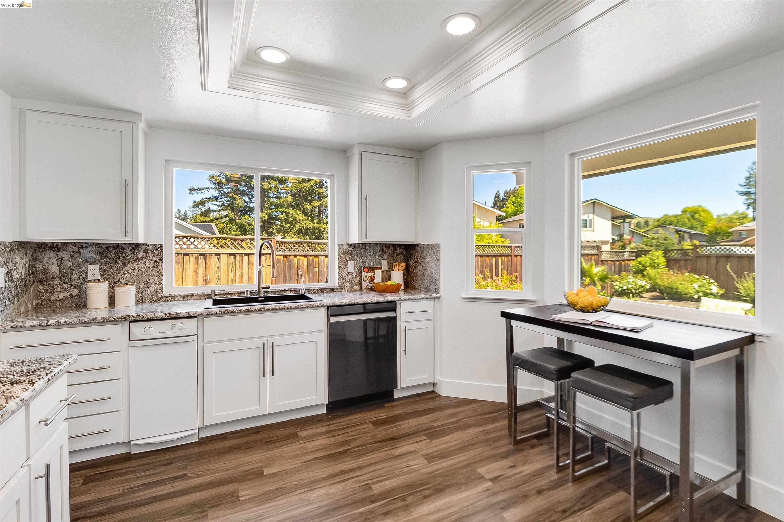 9980 Mangos Drive San Ramon, CA 94583 - Photo 13 of 41 Kitchen featuring dark wood-type flooring, white cabinetry, healthy amount of natural light, light stone counters, and crown molding