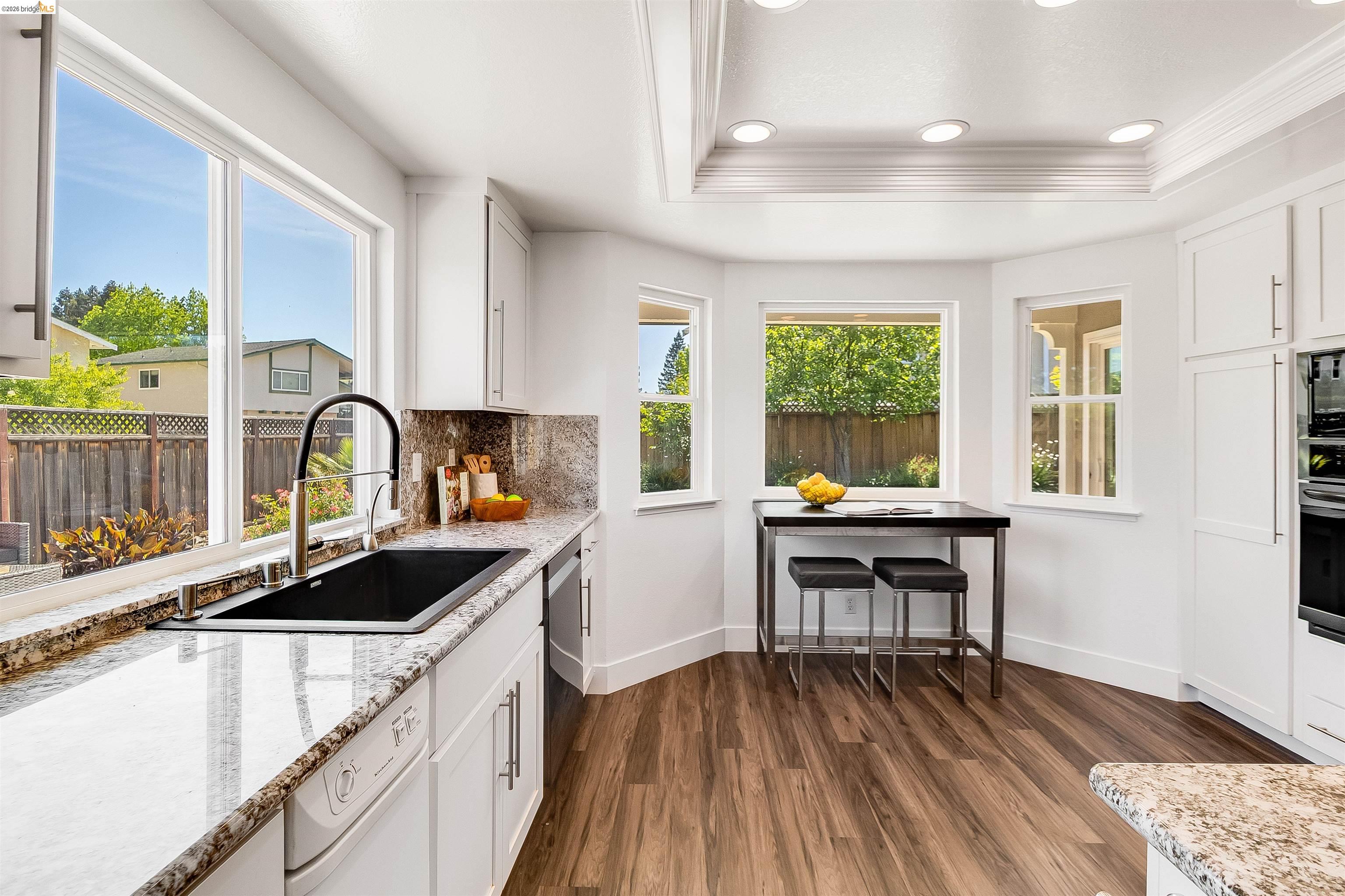 9980 Mangos Drive San Ramon, CA 94583 - Photo 14 of 41 Kitchen with dark wood-style flooring, light stone counters, white cabinetry, tasteful backsplash, and stainless steel appliances