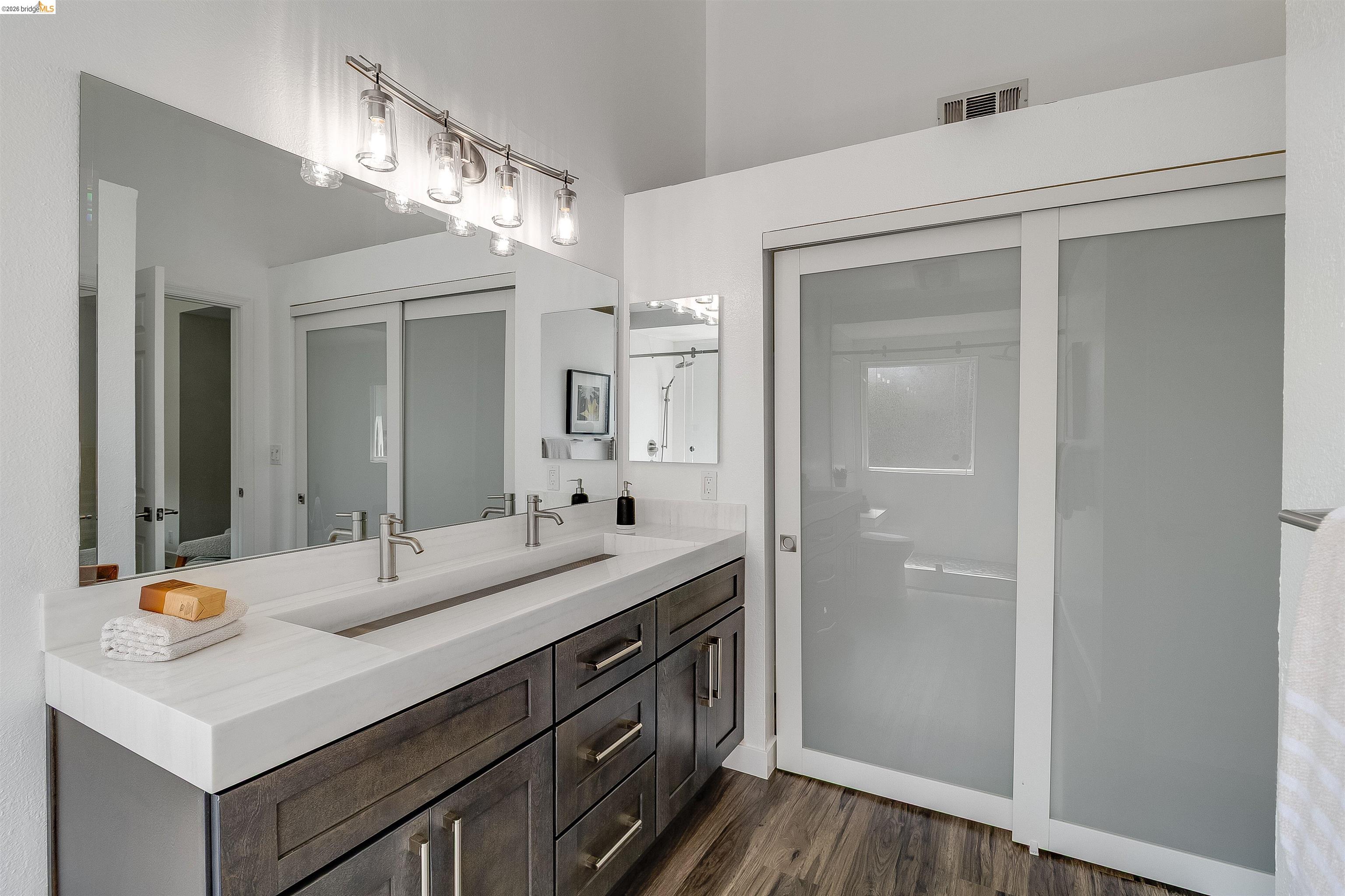 9980 Mangos Drive San Ramon, CA 94583 - Photo 24 of 41 Full bath with double vanity, dark wood-style flooring, and a walk in shower