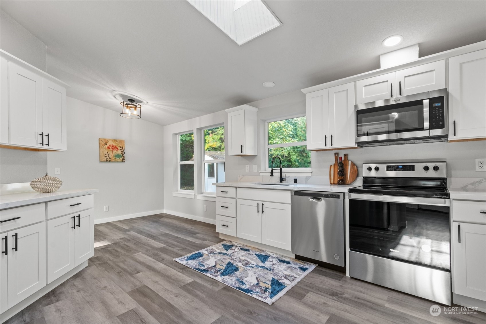 13314 Spring Site Road East Orting, WA 98360 - Photo 11 of 28 a kitchen with stainless steel appliances wooden floor sink and microwave
