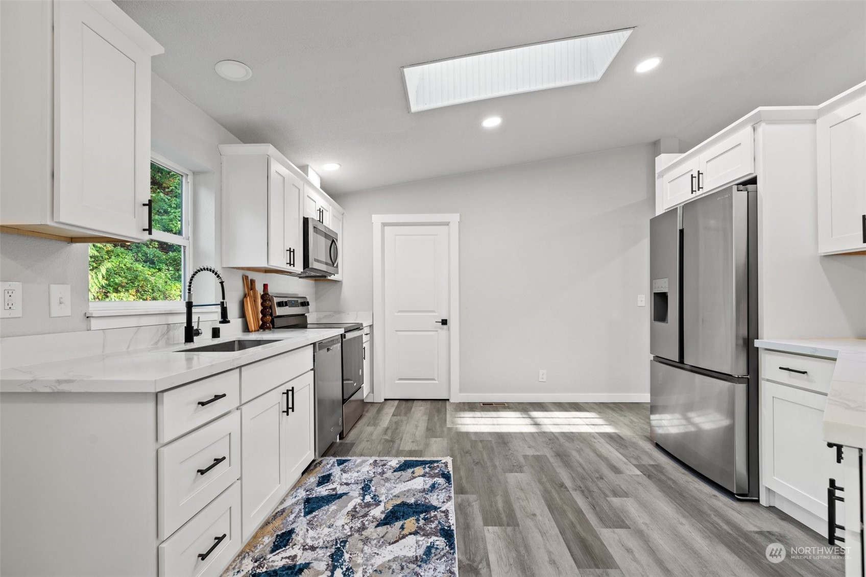 13314 Spring Site Road East Orting, WA 98360 - Photo 13 of 28 a kitchen with white cabinets and stainless steel appliances
