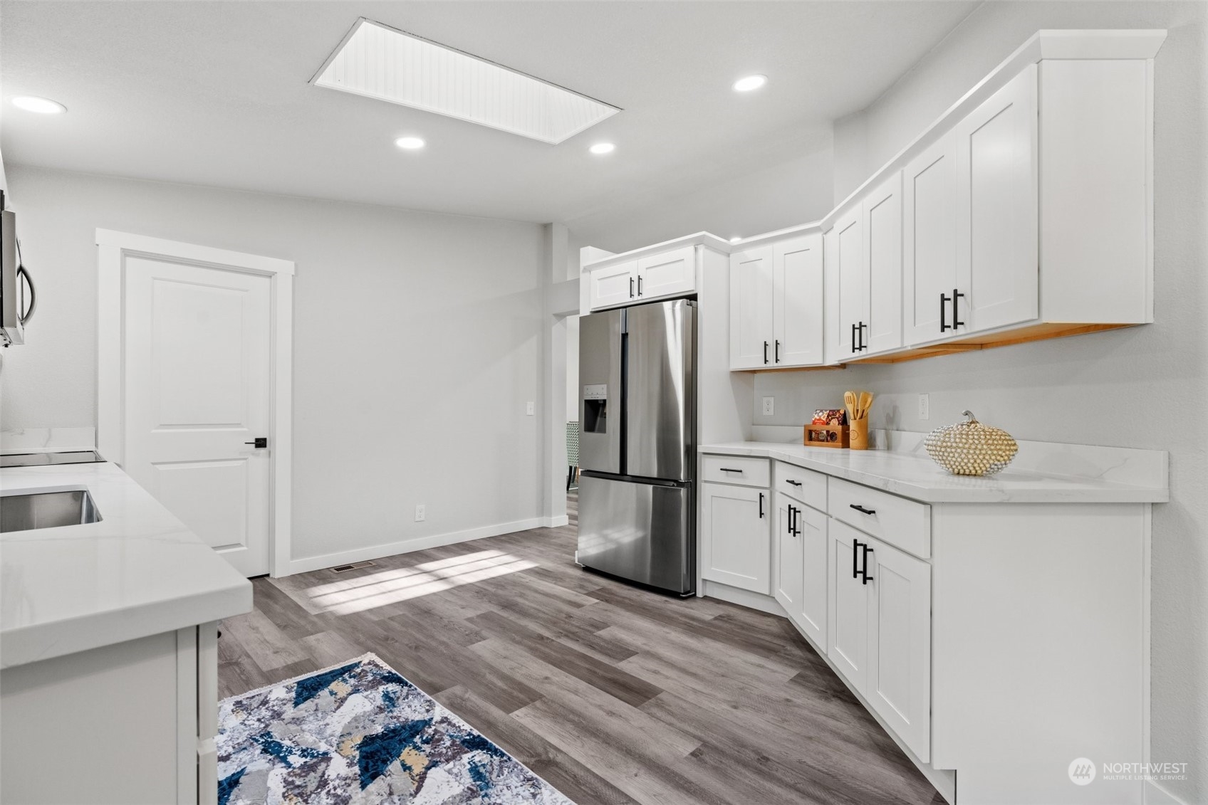 13314 Spring Site Road East Orting, WA 98360 - Photo 14 of 28 a kitchen with granite countertop white cabinets and refrigerator