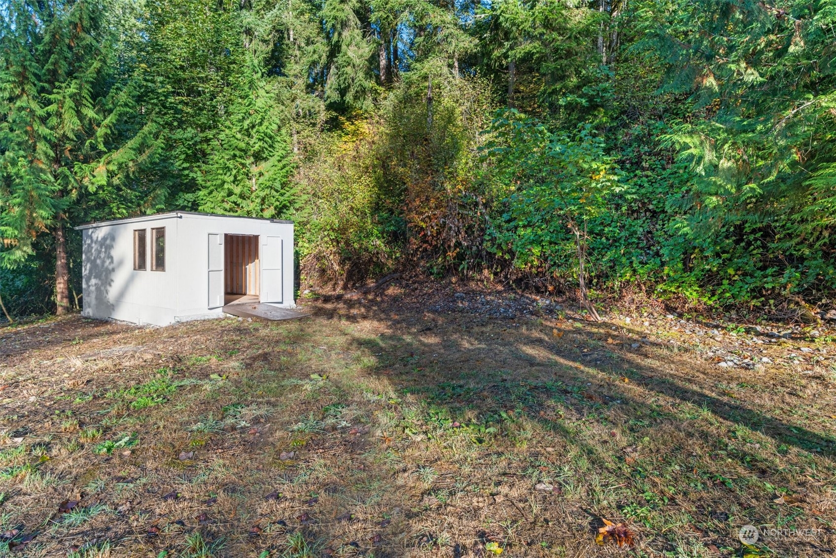 13314 Spring Site Road East Orting, WA 98360 - Photo 28 of 28 a backyard of a house with large trees and plants