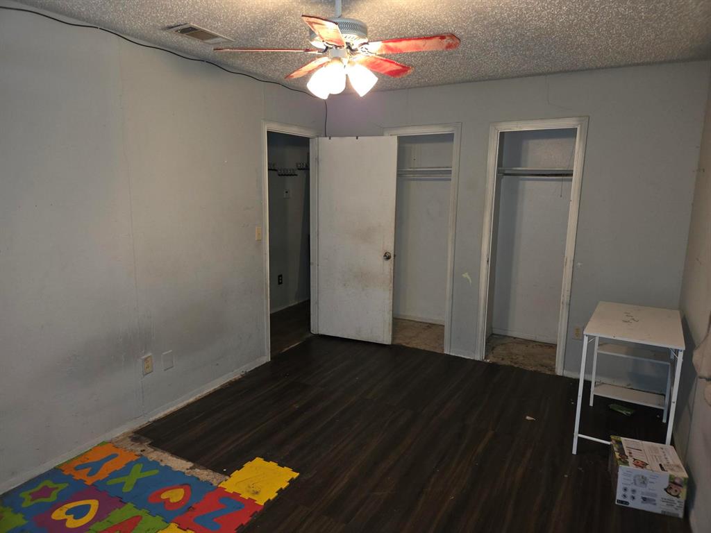 105 Royal Lane Princeton, TX 75407 - Photo 8 of 14 a view of an empty room with wooden floor and a ceiling fan