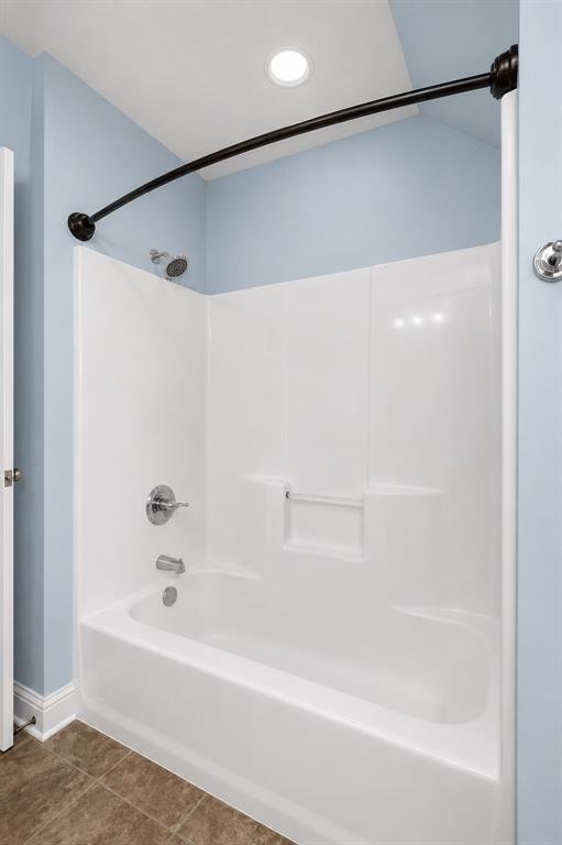 179 Ranchtown Road Elm Grove, LA 71051 - Photo 12 of 26 White bathtub and shower combination with chrome fixtures, integrated shelving, a curved matte black shower rod, recessed lighting, and tile flooring