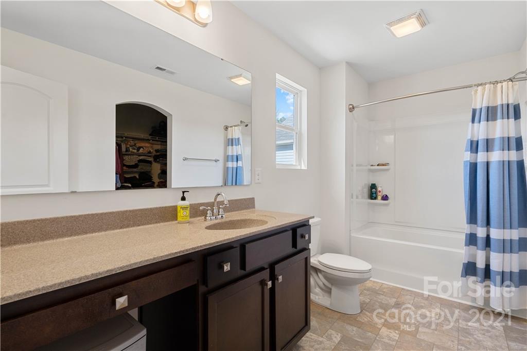 12510 Gotland Road Midland, NC 28107 - Photo 18 of 30 a bathroom with a granite countertop sink toilet a large mirror a shower and a mirror
