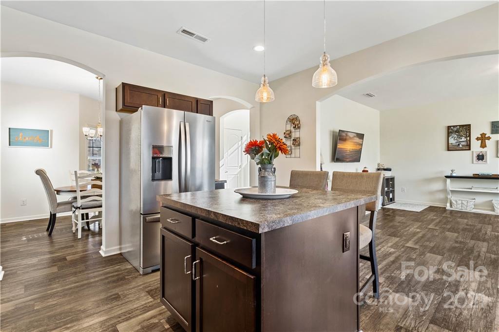 12510 Gotland Road Midland, NC 28107 - Photo 6 of 30 a kitchen with stainless steel appliances kitchen island granite countertop a table chairs and a refrigerator
