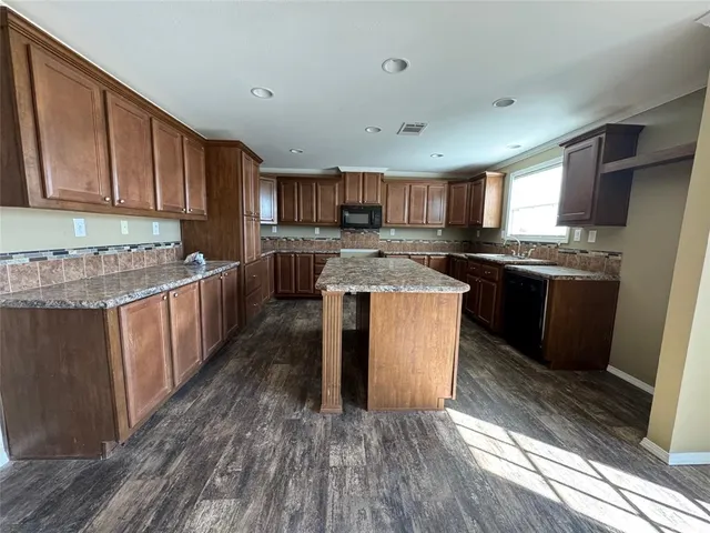 a kitchen with stainless steel appliances granite countertop a stove a sink dishwasher and a refrigerator