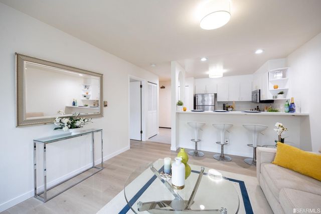 a kitchen with stainless steel appliances kitchen island granite countertop a refrigerator and a stove