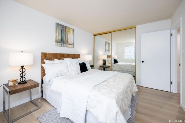 a spacious bedroom with a bed and a lamp