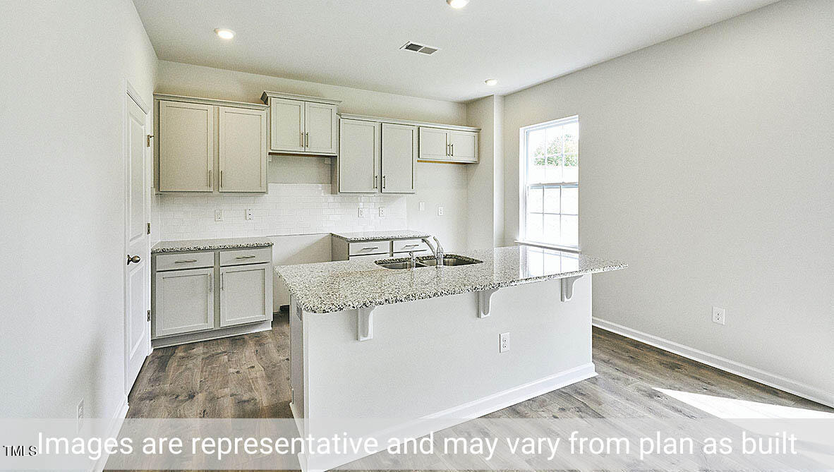 1702 Carter Daniel Drive Graham, NC 27253 - Photo 5 of 27 a kitchen with stainless steel appliances granite countertop a sink and a stove