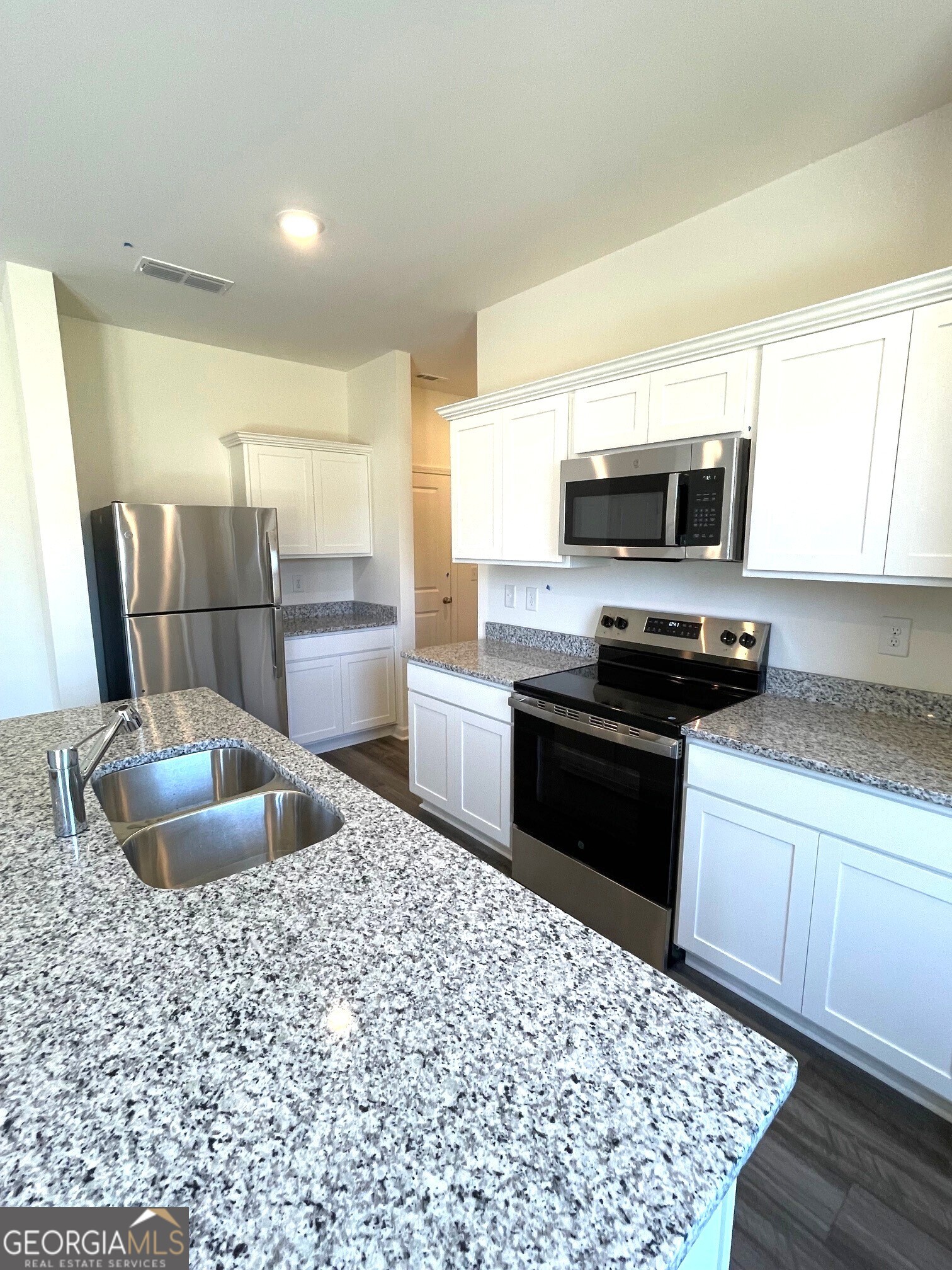 24 Rowlett Place Winder, GA 30680 - Photo 5 of 17 a kitchen with a sink a stove and microwave