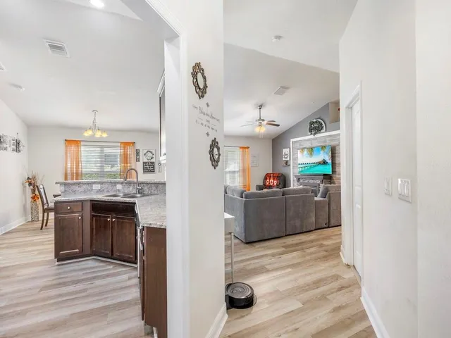 a large kitchen with a center island and wooden floor