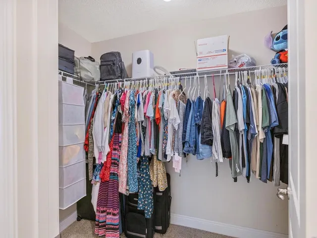 a view of walk in closet with clothes