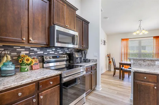 a kitchen with stainless steel appliances granite countertop a stove a sink and a microwave