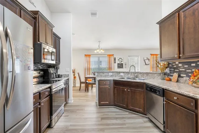 a kitchen with stainless steel appliances granite countertop a stove a sink dishwasher and a refrigerator