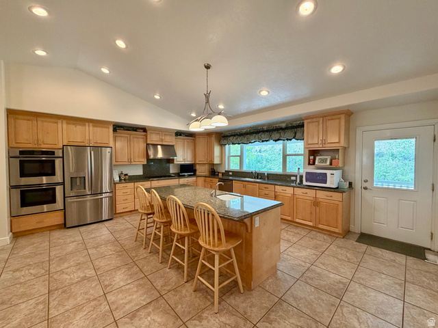 1133 Paris Canyon Road Paris, ID 83261 - Photo 15 of 75 Spacious kitchen featuring an expansive center island with seating, granite-style countertops, stainless steel appliances, and abundant wood cabinetry with a breathtaking view