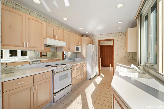 a kitchen with stainless steel appliances granite countertop a sink and a large window