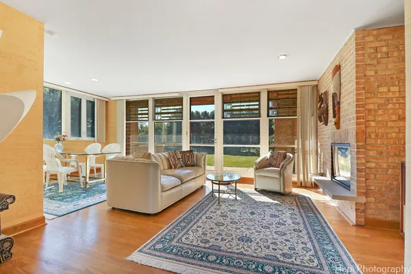 a living room with furniture fireplace and a large window