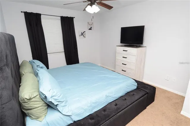 a bedroom with a bed and painting on the wall