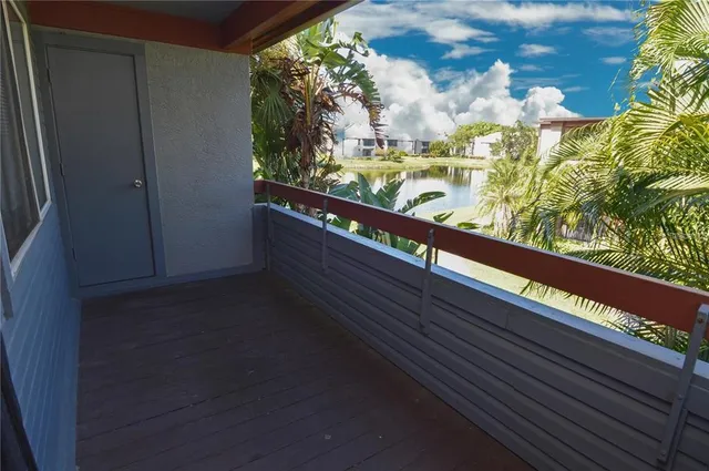 a row of palm trees and swimming pool in the backyard of a house