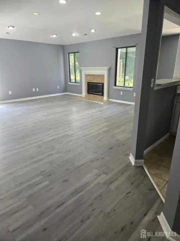 an empty room with wooden floor and fireplace