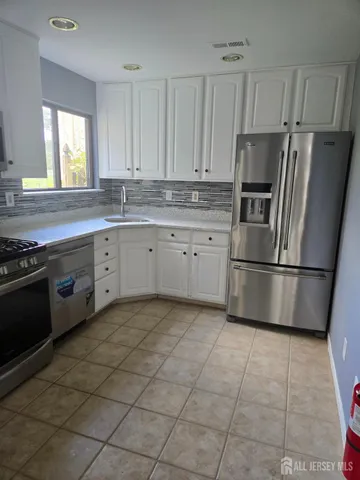 a kitchen with stainless steel appliances granite countertop a stove a refrigerator and a refrigerator