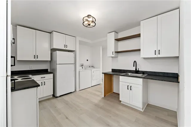 a kitchen with granite countertop a refrigerator stove top oven and sink