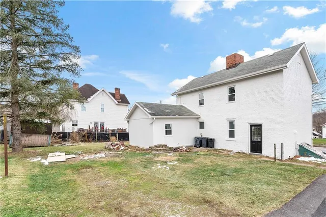 a view of a white house with a yard