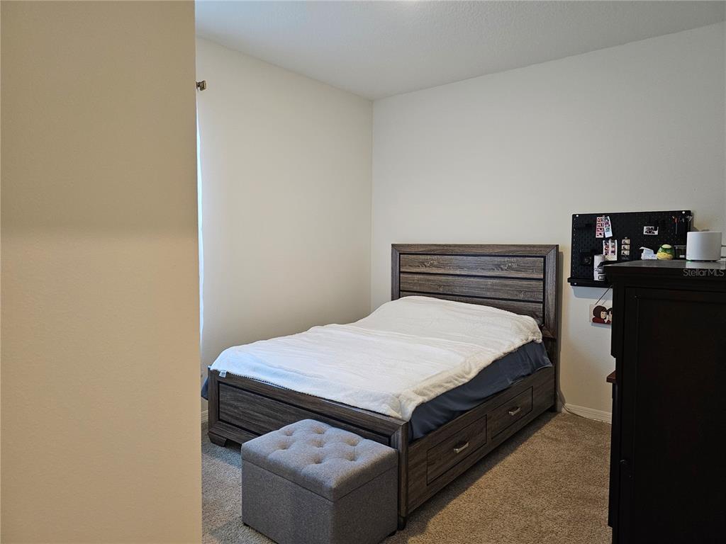 2045 Rankin Street Kissimmee, FL 34744 - Photo 22 of 38 a bed sitting in a bedroom next to a wall
