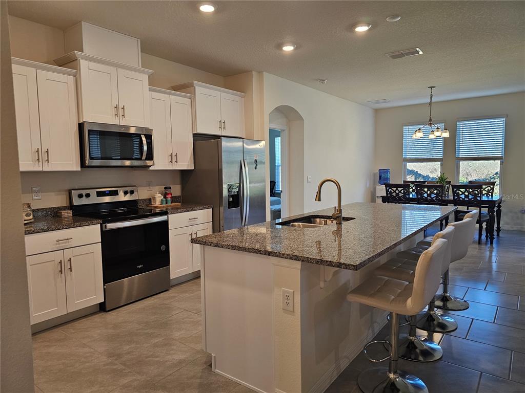 2045 Rankin Street Kissimmee, FL 34744 - Photo 6 of 38 a kitchen with stainless steel appliances granite countertop a sink a stove top oven a counter space and cabinets