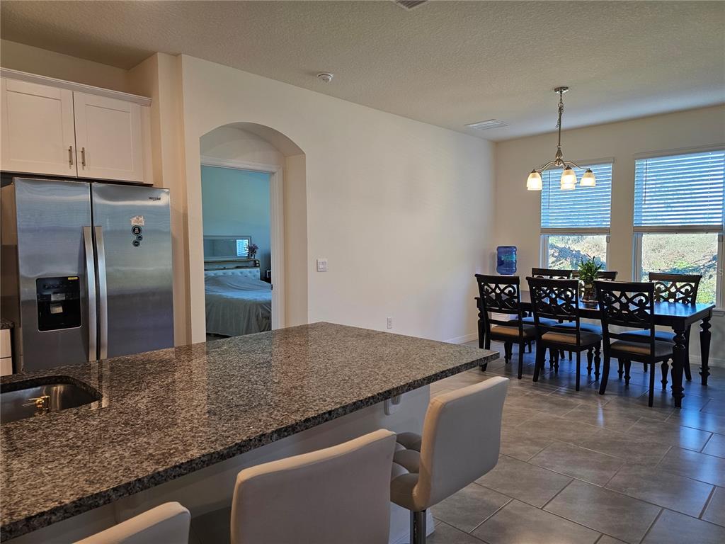 2045 Rankin Street Kissimmee, FL 34744 - Photo 8 of 38 a kitchen with kitchen island granite countertop a table and chairs