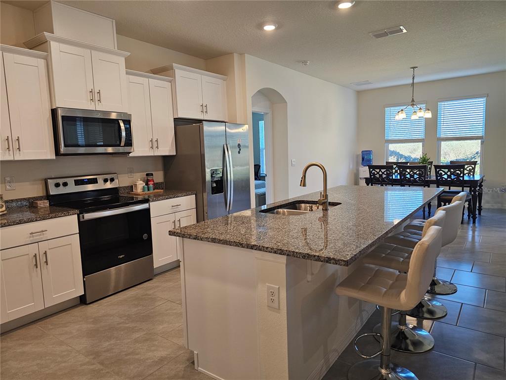 2045 Rankin Street Kissimmee, FL 34744 - Photo 9 of 38 a kitchen with stainless steel appliances granite countertop a sink a stove and a refrigerator