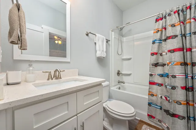 a bathroom with a sink toilet vanity and shower