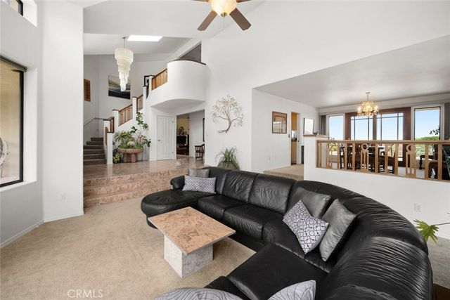 a living room with furniture large windows and garden view