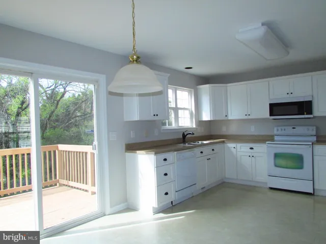 a kitchen with granite countertop a sink a center island a stove and a window