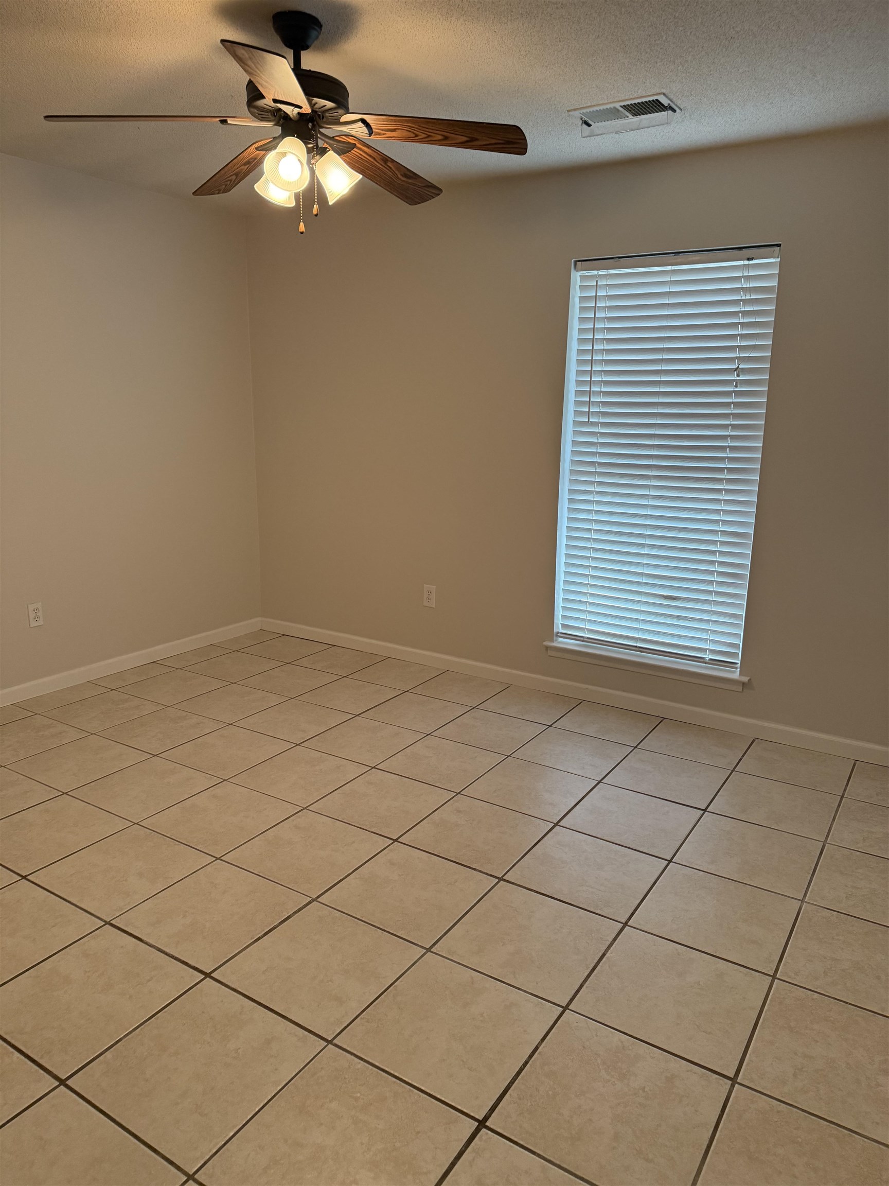 928 Poplar Leaf Road Collierville, TN 38017 - Photo 6 of 8 Empty room featuring a ceiling fan, light tile patterned floors, and a textured ceiling