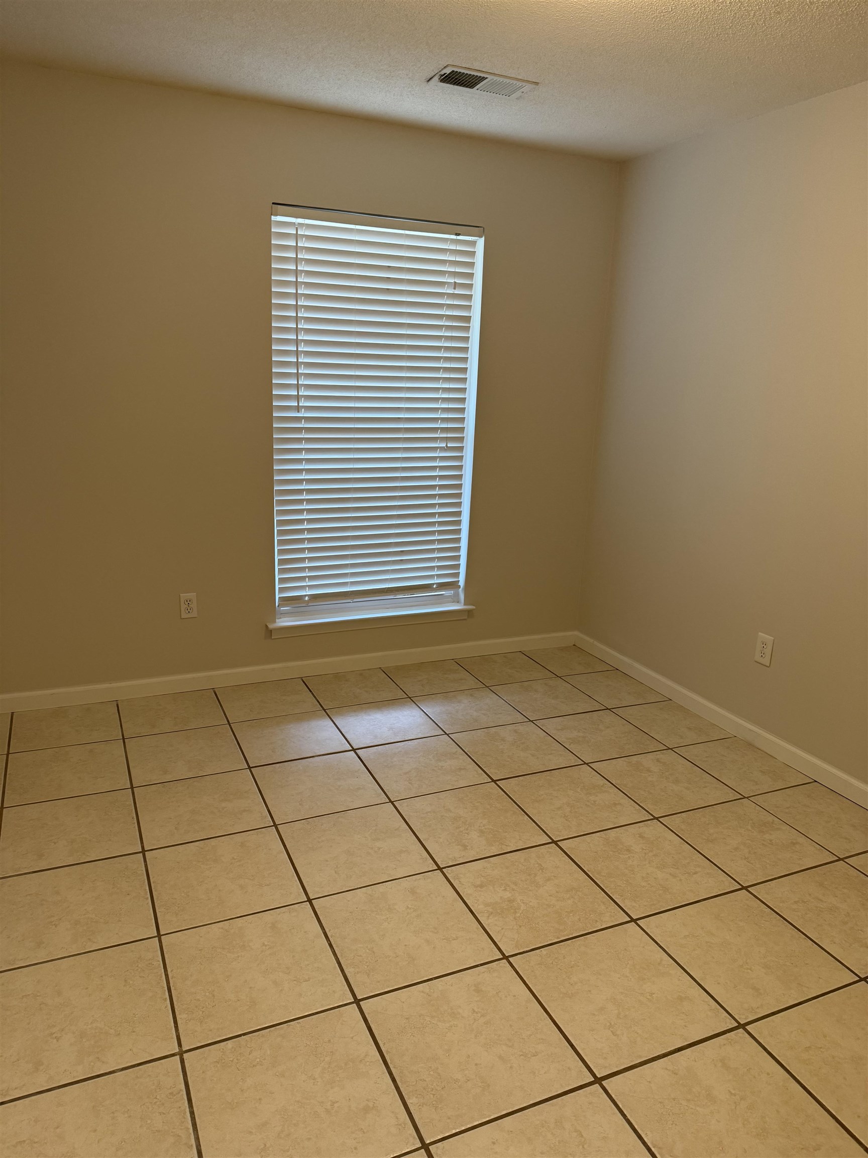 928 Poplar Leaf Road Collierville, TN 38017 - Photo 7 of 8 Empty room featuring light tile patterned flooring and a textured ceiling