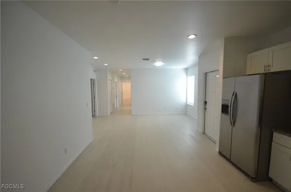 a view of a refrigerator in kitchen and a window
