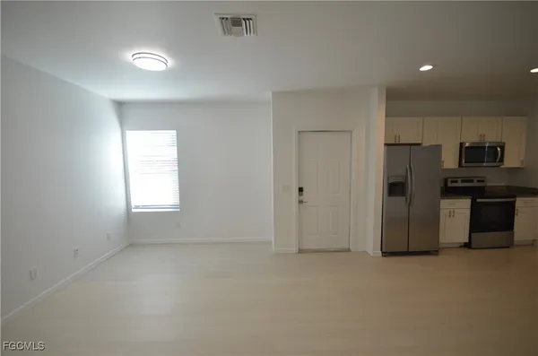 a view of a kitchen with refrigerator and microwave