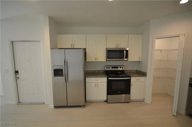 a kitchen with stainless steel appliances and white cabinets