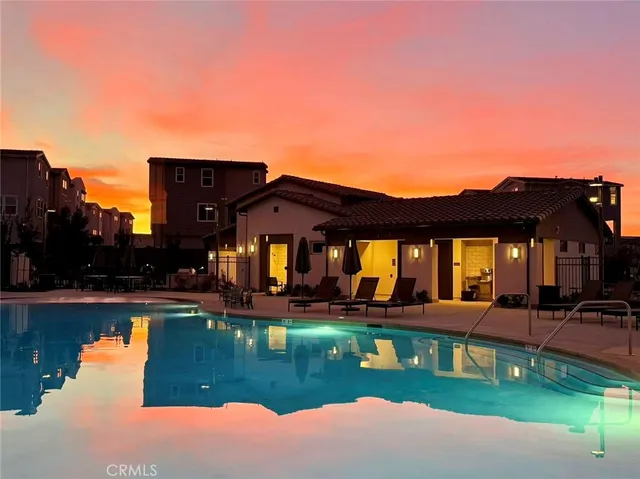 a view of a house with pool and chairs