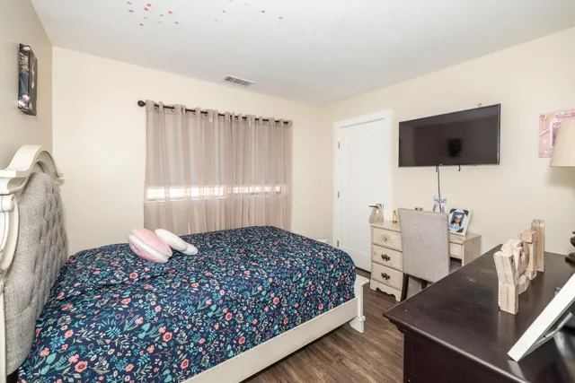 a bedroom with a bed and a flat screen tv