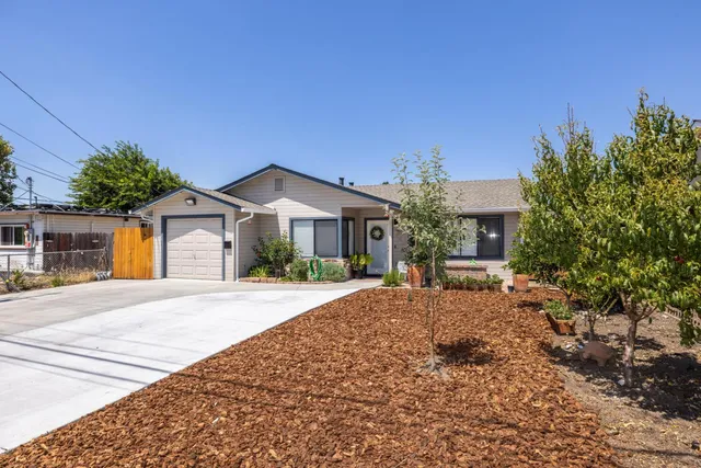 a front view of a house with a yard and trees