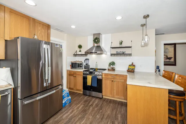 a kitchen with stainless steel appliances granite countertop a refrigerator stove and sink