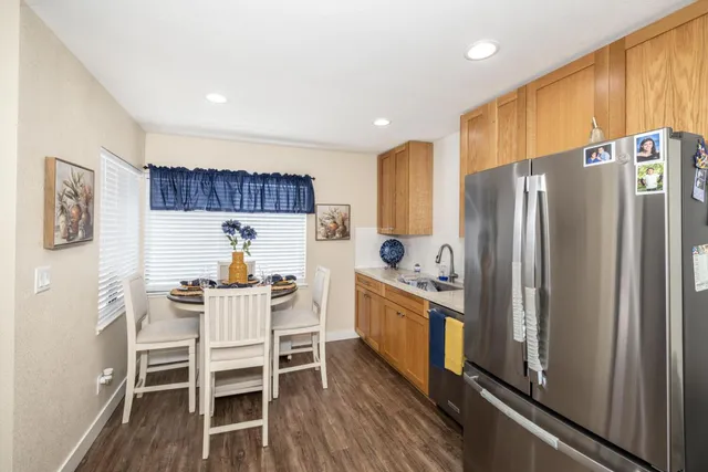 a kitchen with stainless steel appliances a refrigerator a stove a sink and chairs