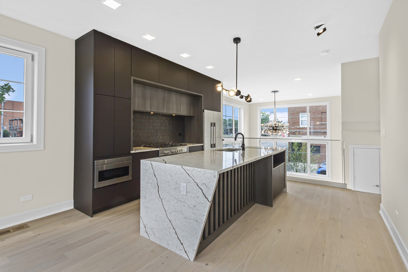 334 East Pershing Road Chicago, IL 60653 - Photo 8 of 42 a large kitchen with kitchen island a large counter top stainless steel appliances and cabinets