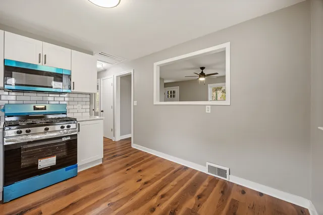 a kitchen with wooden floor and a stove top oven