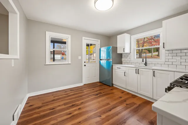 a kitchen with a sink cabinets and wooden floor